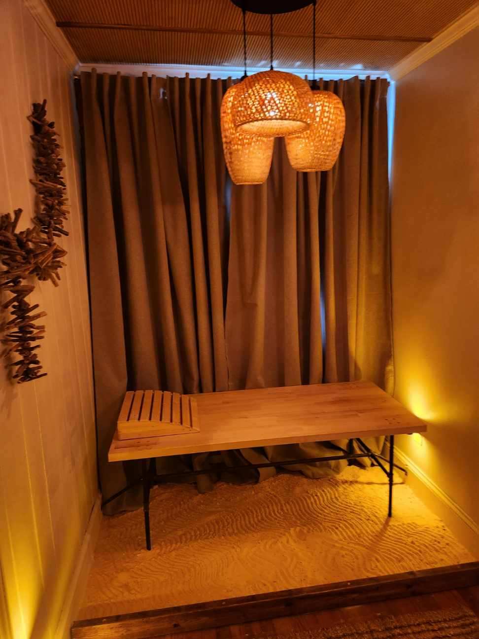 The salt room, lit warm amber under woven pendant lamps with a wooden bench
