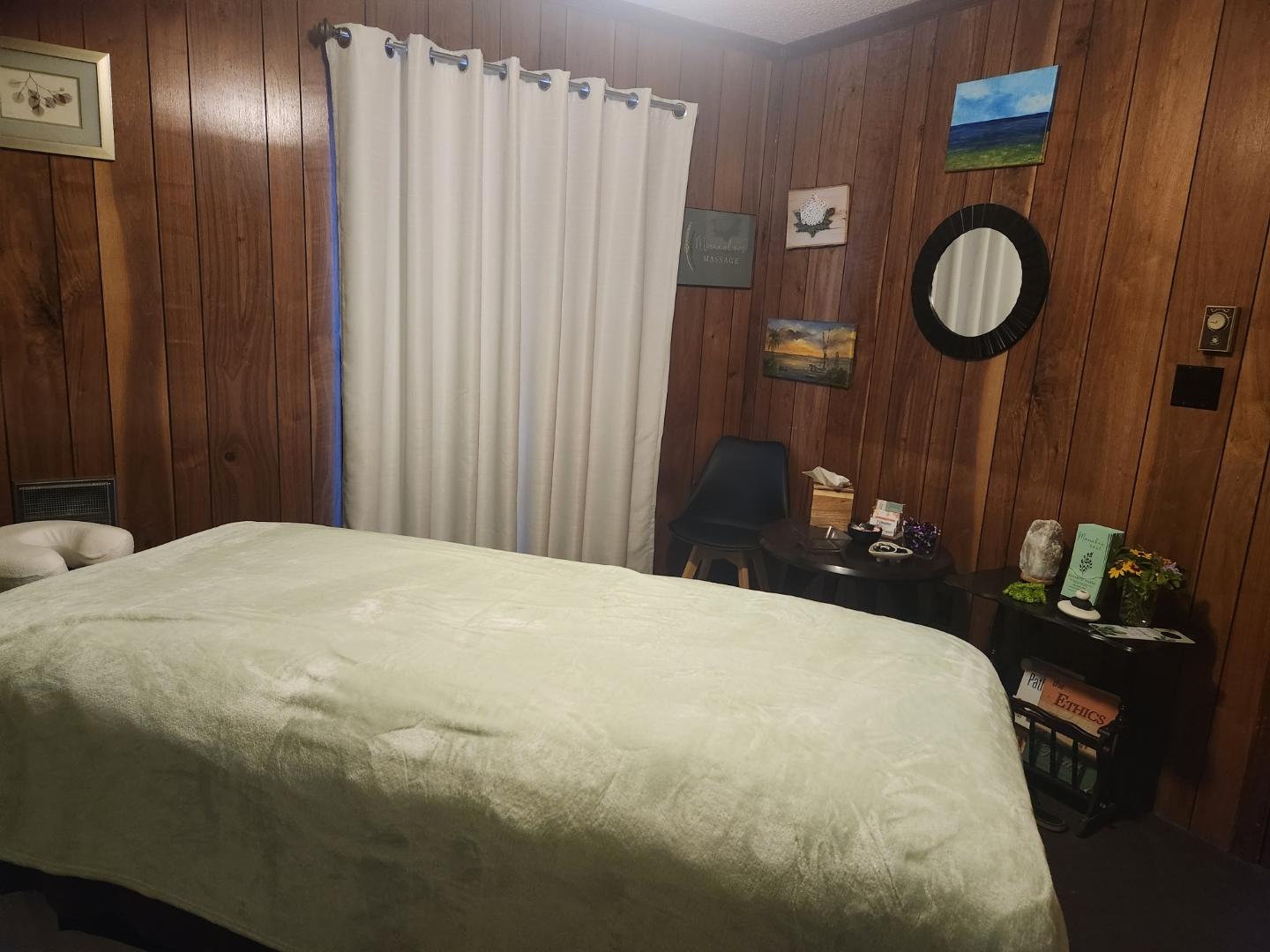 My treatment room with the massage table made up and a salt lamp glowing in the corner